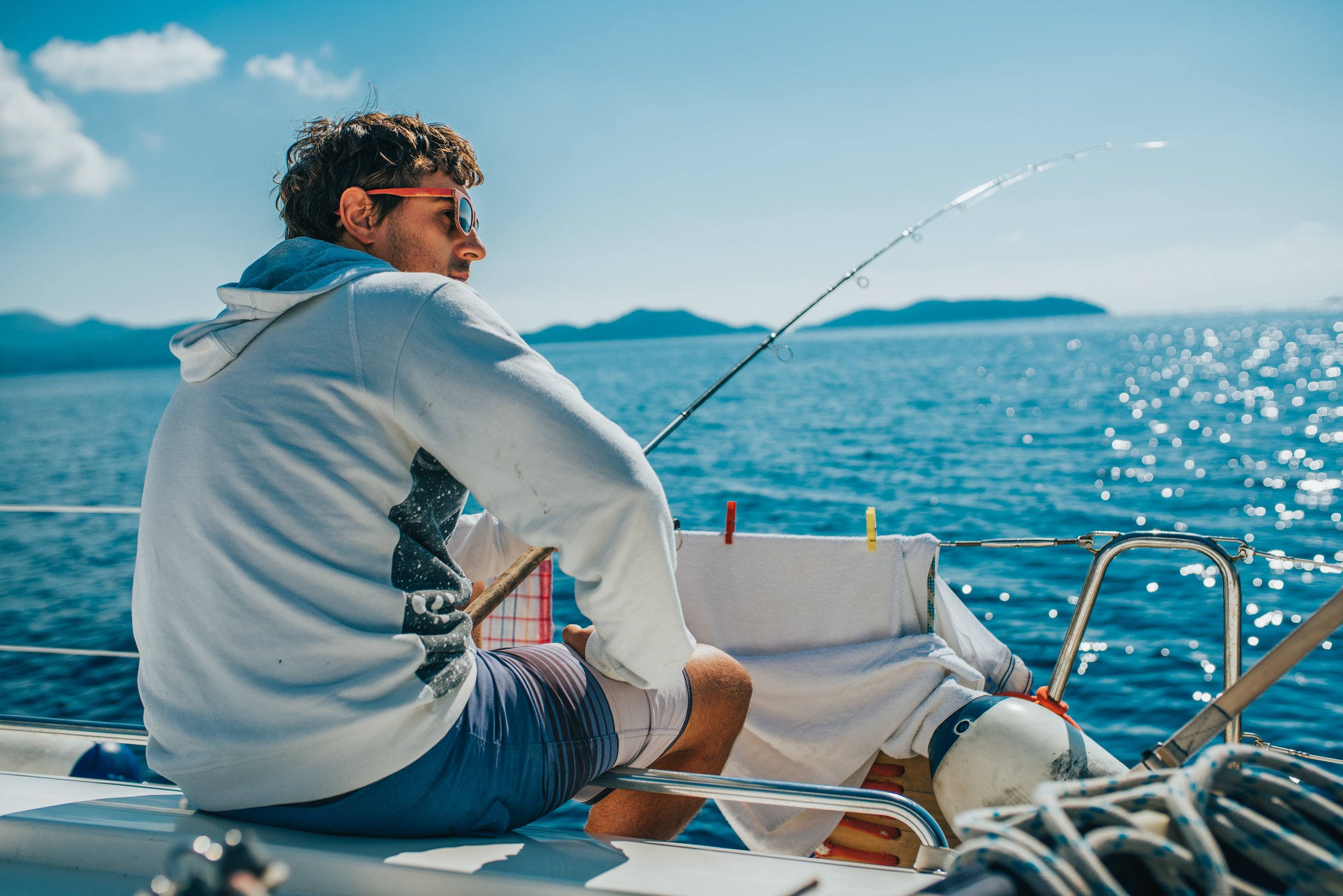 Man sitting and fishing on boat